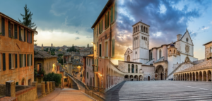 Perugia vs. Assisi: Why the Capital is the Best Base for Your Umbrian Adventure This comparison image captures the two sides of Umbria: the grand, lively city of Perugia (left) and the iconic spiritual site of Assisi (right). While Assisi is a must-see landmark, staying in Perugia offers a more dynamic and practical travel experience.